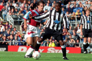 Newcastle United's Andy Cole (r) breaks away from West Ham United's Ian Bishop (l)